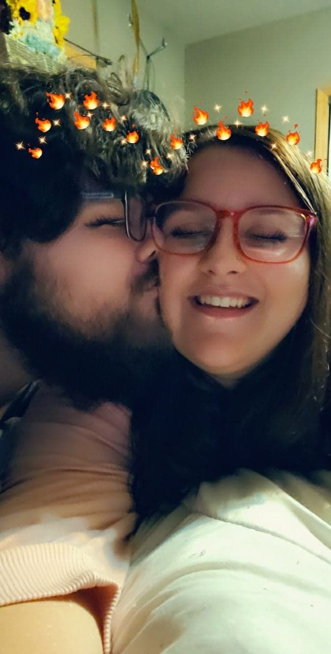 A couple shares an intimate moment while wearing holiday light decorations on their heads.