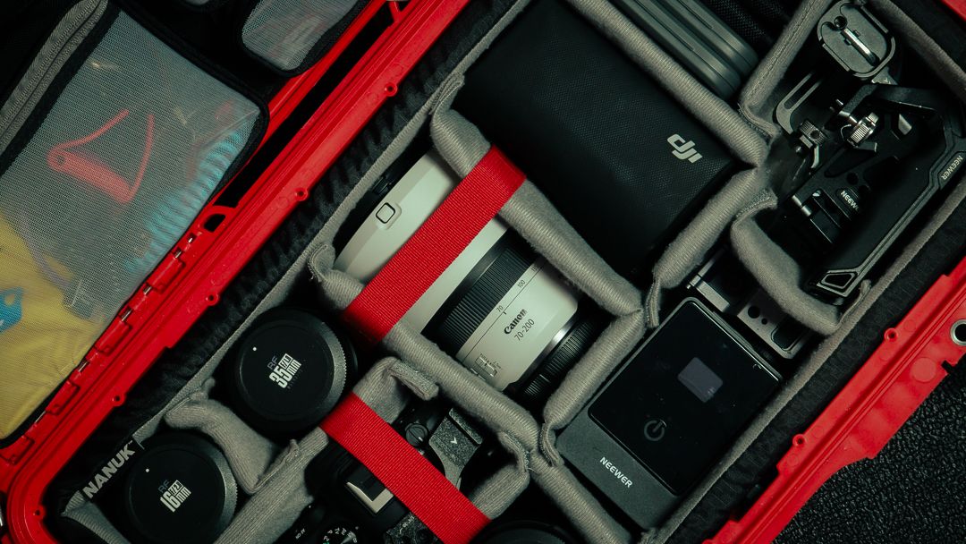 Professional camera equipment organized in Nanuk case — lenses, batteries, and tools used by South Florida photographer Mannyportraits.