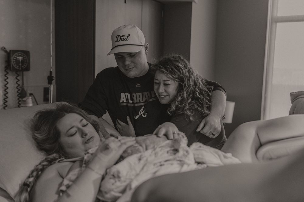 Black and white photo series capturing emotional moments during childbirth in a hospital room.