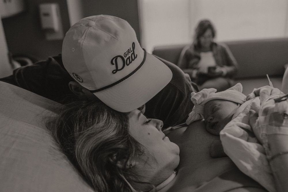 Black and white birth photography showing emotional support during labor in hospital setting.