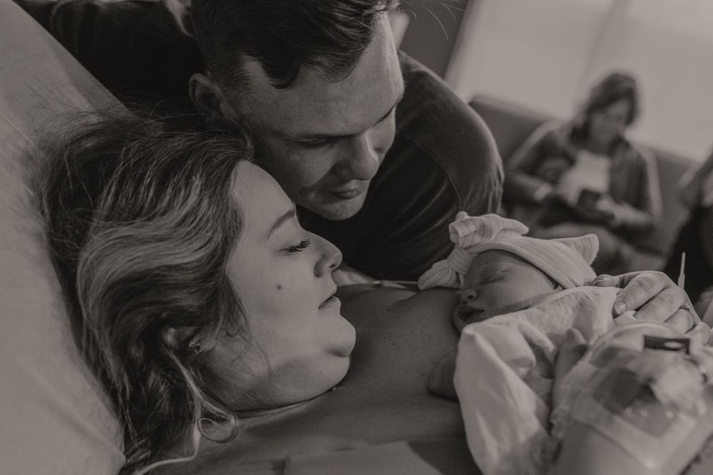 Intimate black and white photography sequence of childbirth moments in hospital room.