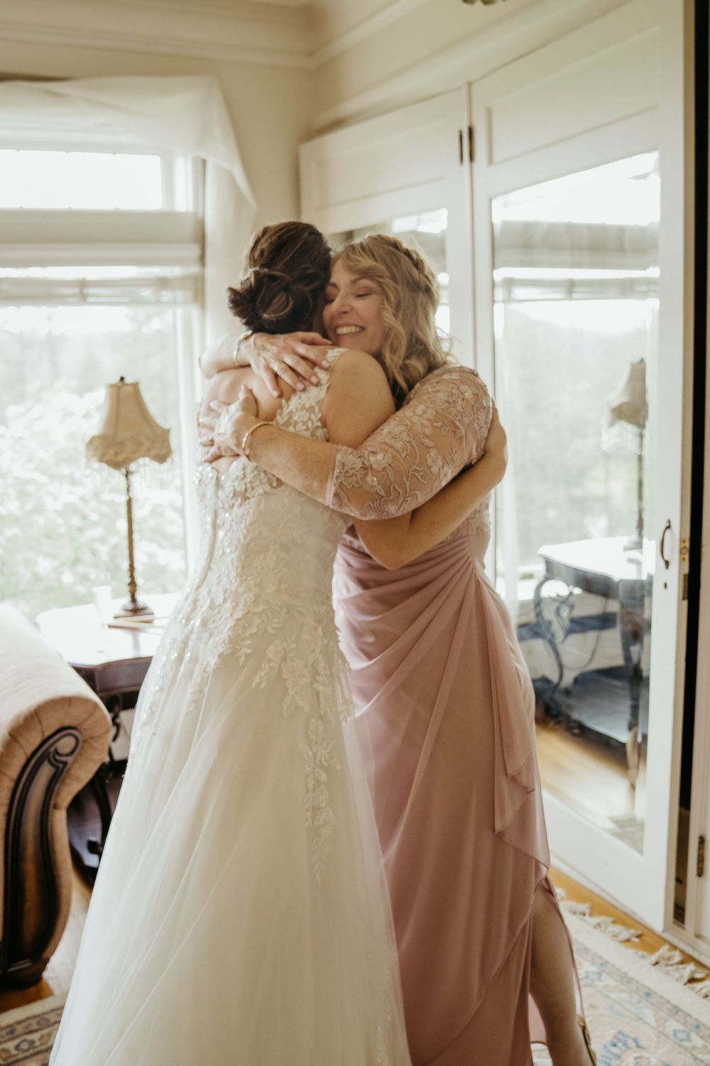 Emotional wedding moment showing embrace in elegant indoor setting.