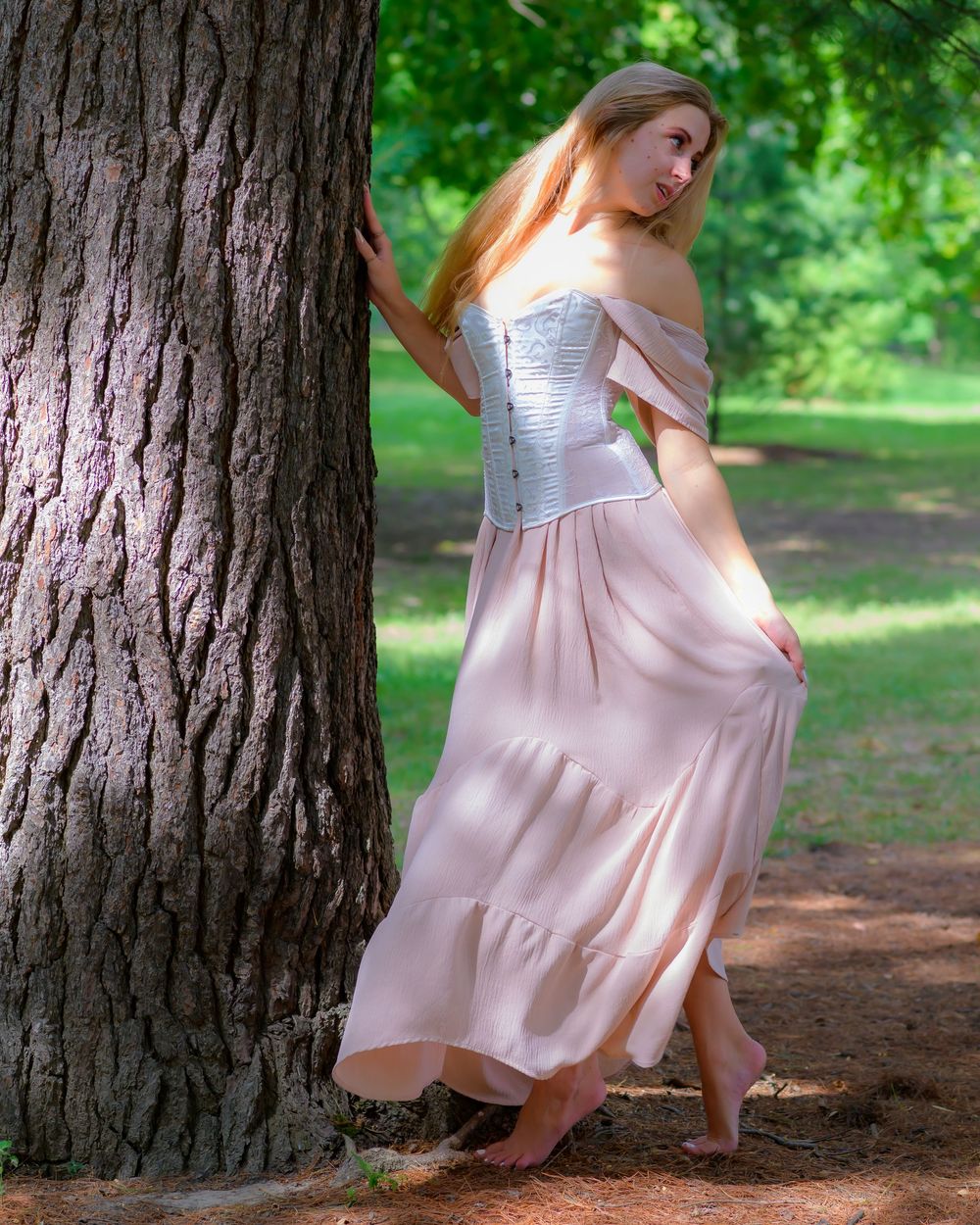 Flowing pink dress captured in artistic motion sequence against tree backdrop.