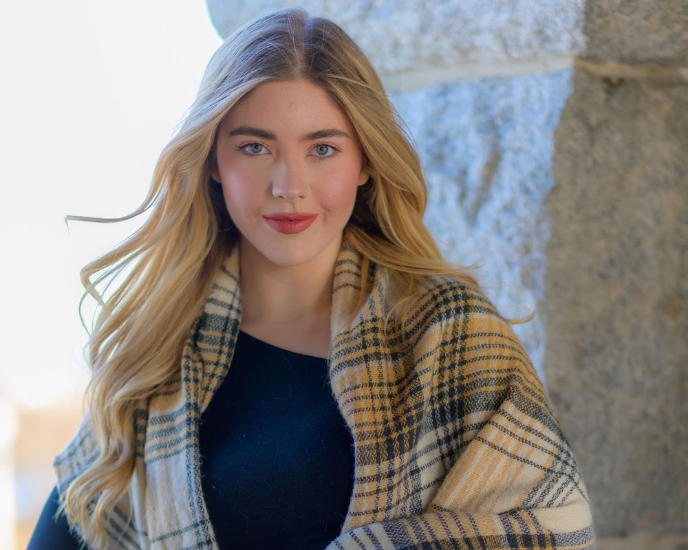 Fashion portraits featuring a plaid coat and black top against stone columns.