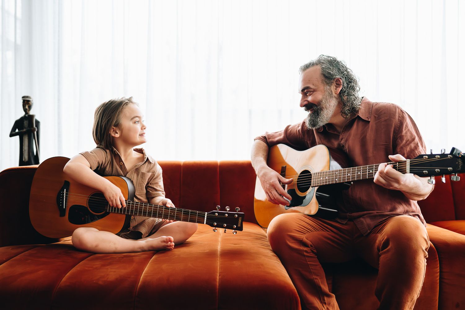 Father and son playing guitar during a newborn and family photoshoot at home by Melbourne newborn and family photographer Pei A Photography