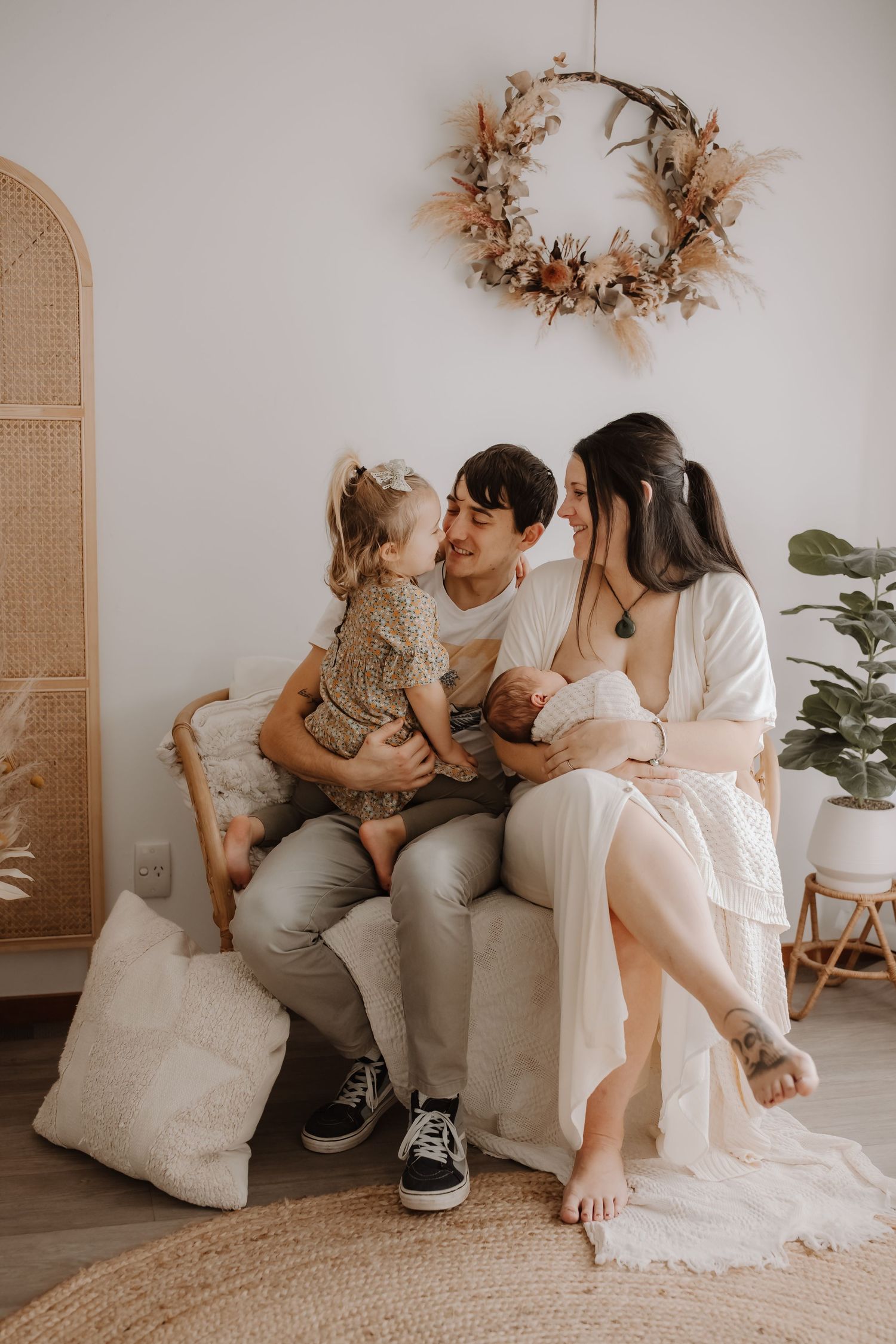 Parents cuddling their newborn baby during a cozy in-home lifestyle photography session in Westport.