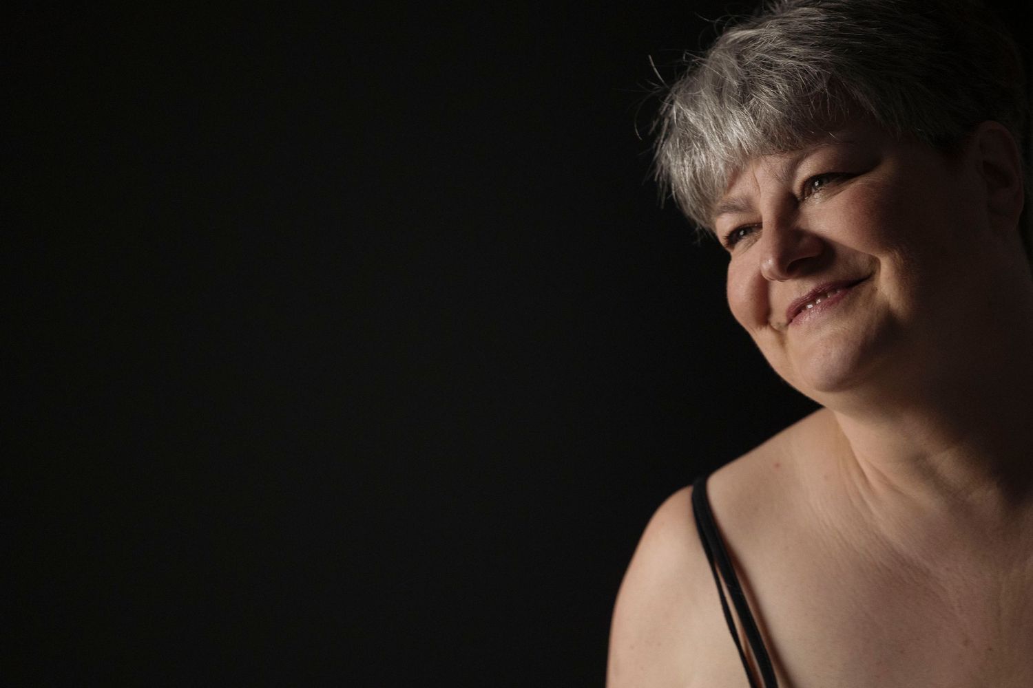 Artistic profile portrait against dark background showing contemplative expression.