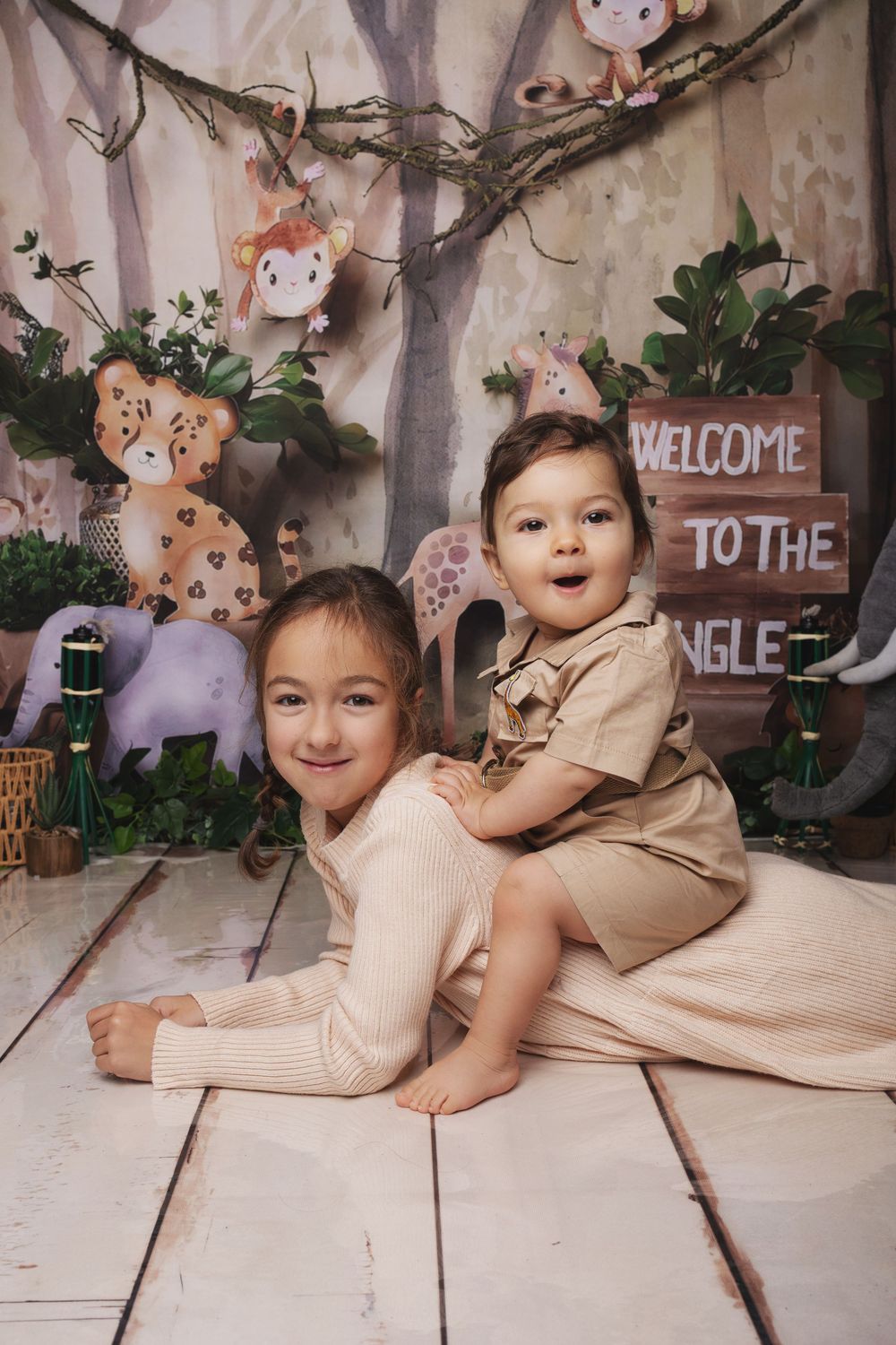 A series of four connected photos showing a baby on a tiled floor with decorative woodland-themed elements.