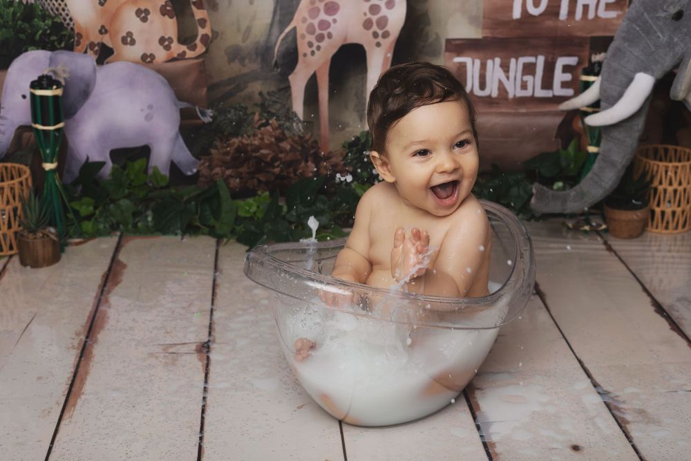A collage of baby bath time photos showing joyful moments with bubbles and splashing in a white tub.