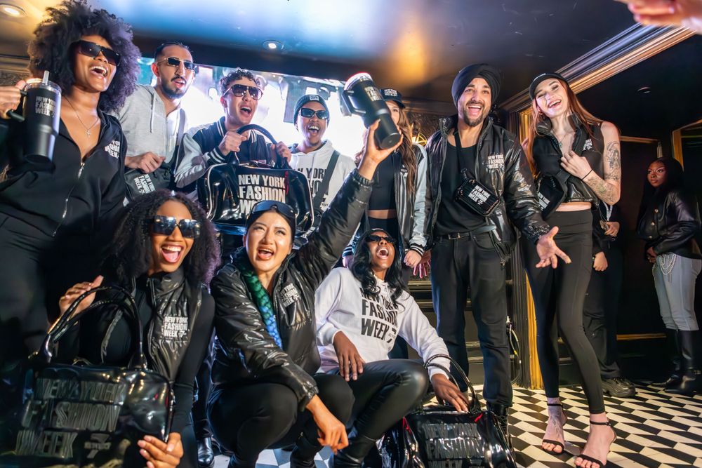 A lively group poses together at a nightclub with a black and white checkered floor and ambient lighting.