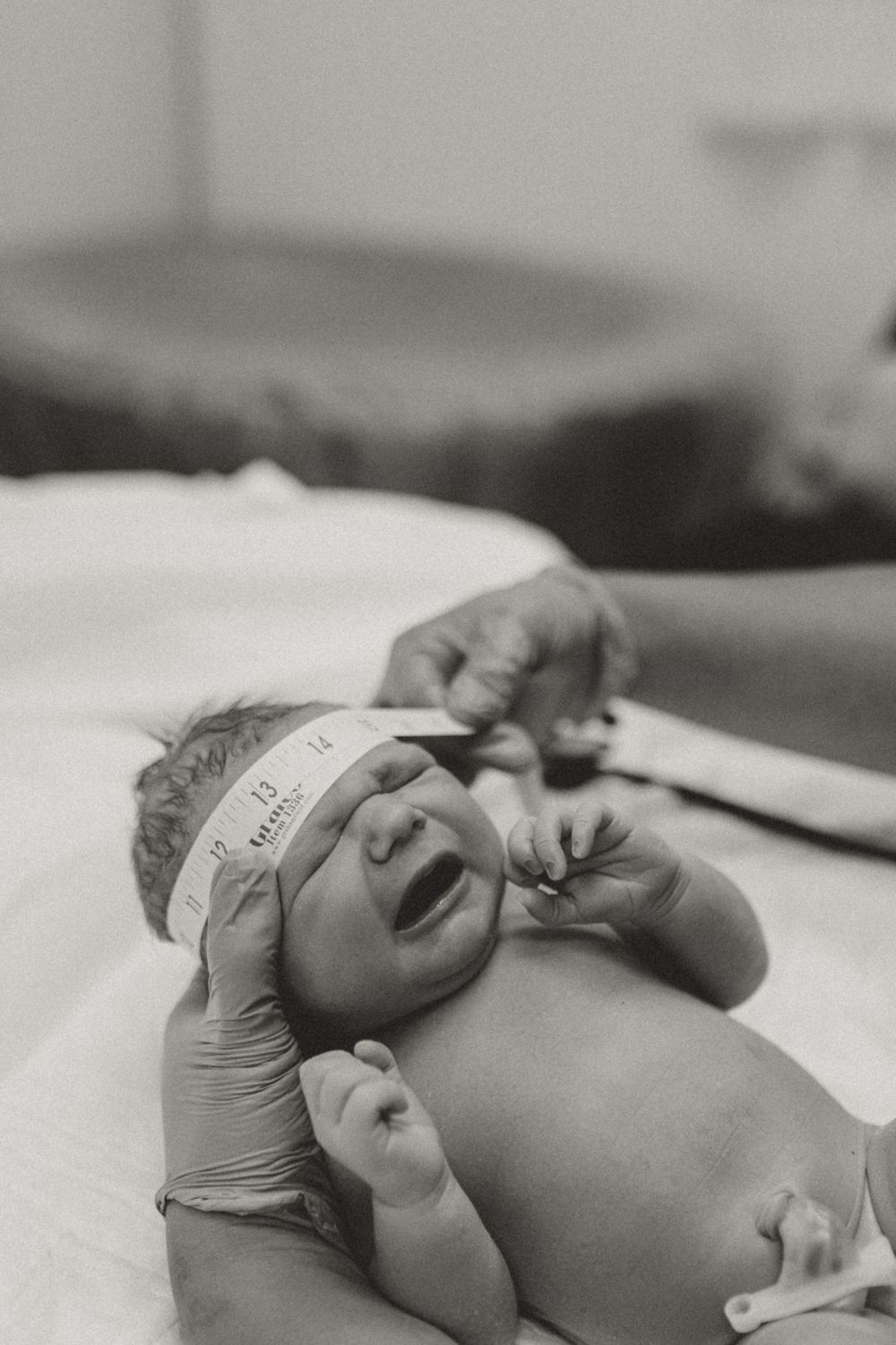 Newborn baby lying on a medical examination table during health check.