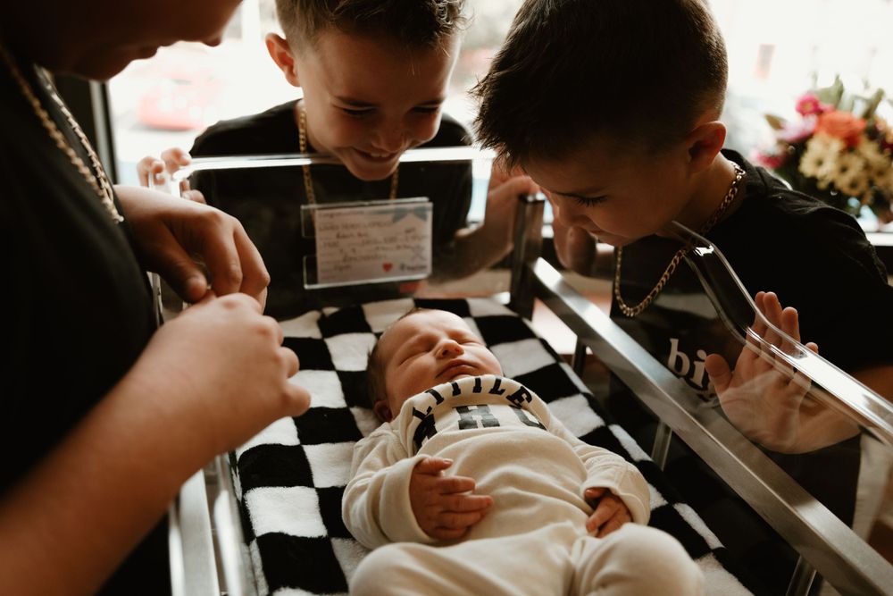 Medical staff examining a newborn in a hospital room setting.
