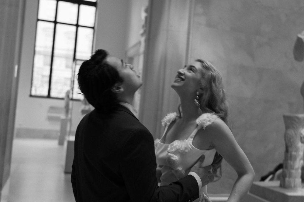 A joyful black and white photo capturing a candid laughing moment in an indoor setting.