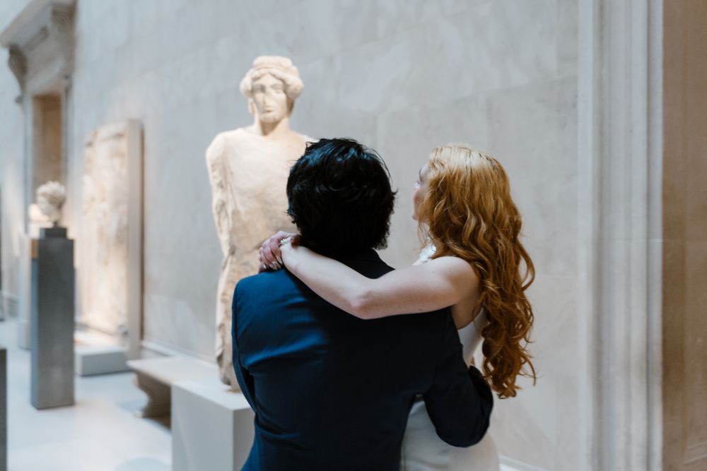 A couple views classical marble statues in an art museum gallery.