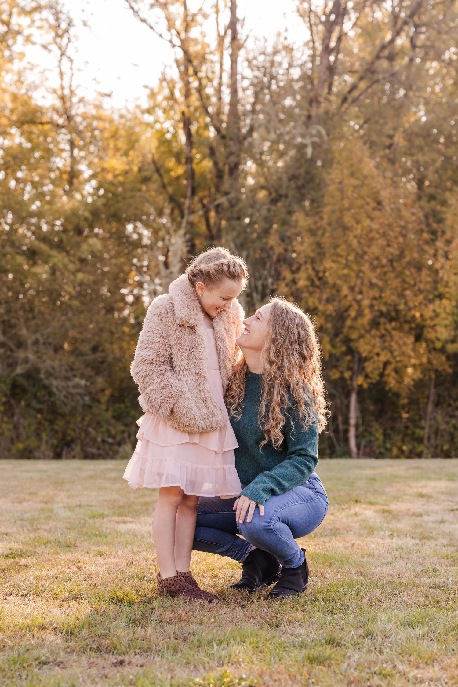 Sweet autumn moment captured in a sunlit field with fall foliage in the background on a golden evening.