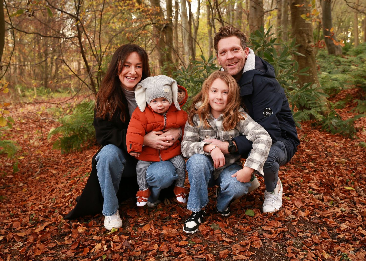 A joyful family enjoying a moment together in the tranquil surroundings of Dunnottar Woods, capturing the beauty of nature and connection