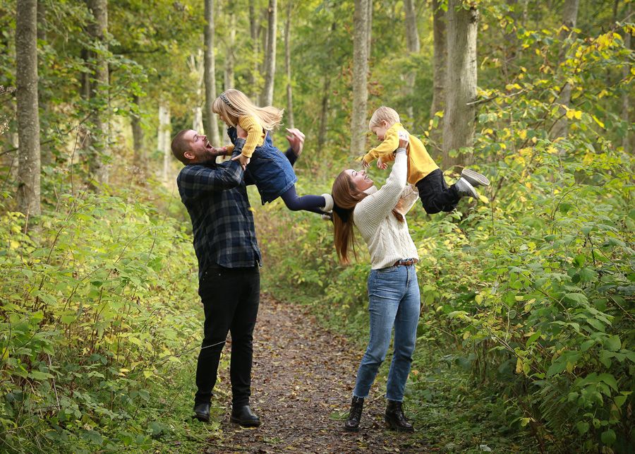A joyful family enjoying a moment together in the tranquil surroundings of Dunnottar Woods, capturing the beauty of nature and connection
