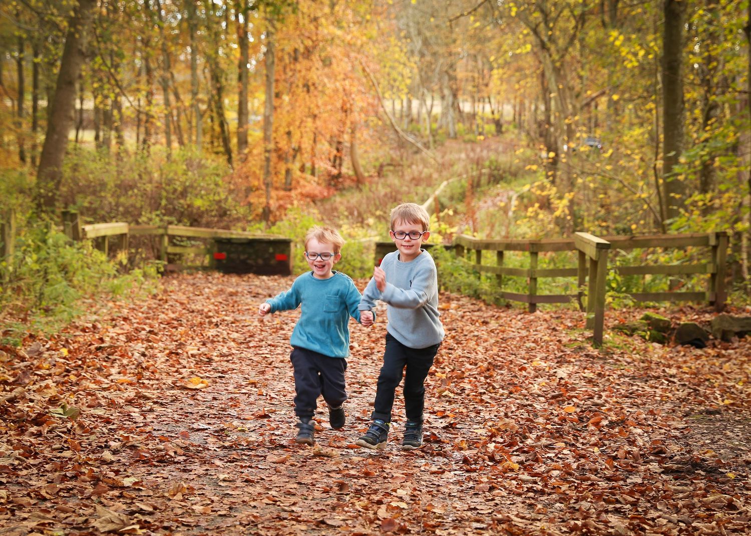 two children playing and exploring in the serene environment of Dunnottar Woods, capturing the joy and wonder of childhood