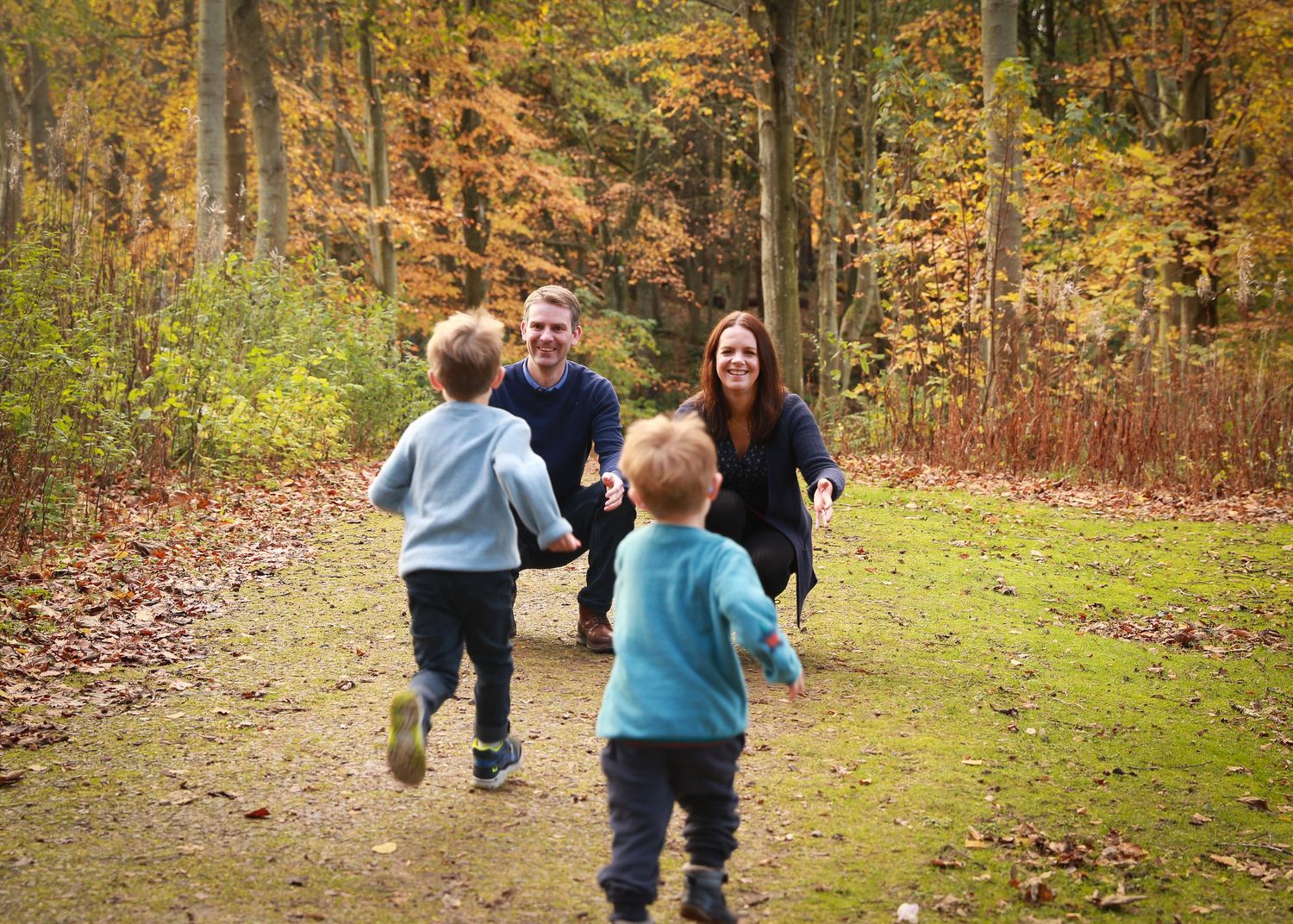 A joyful family enjoying a moment together in the tranquil surroundings of Dunnottar Woods, capturing the beauty of nature and connection