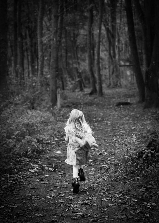 A curious child exploring the peaceful surroundings of the woods, capturing a sense of wonder and adventure in a natural outdoor photography