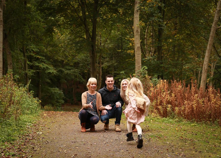 A joyful family enjoying a moment together in the tranquil surroundings of Dunnottar Woods, capturing the beauty of nature and connection