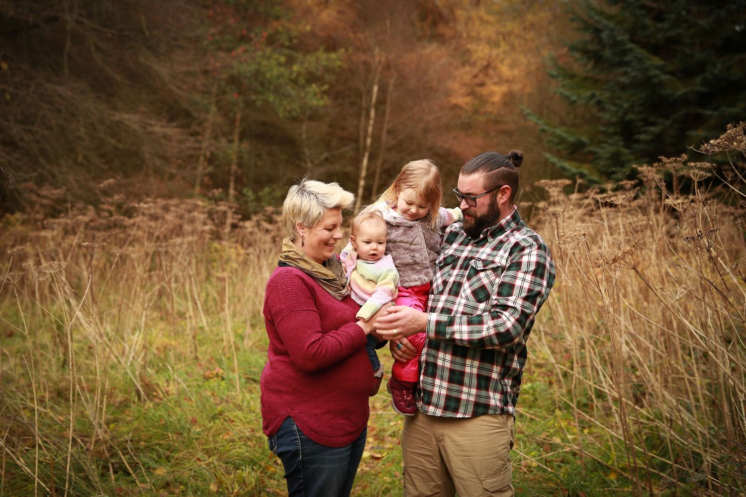 A joyful family enjoying a moment together in the tranquil surroundings of Dunnottar Woods, capturing the beauty of nature and connection