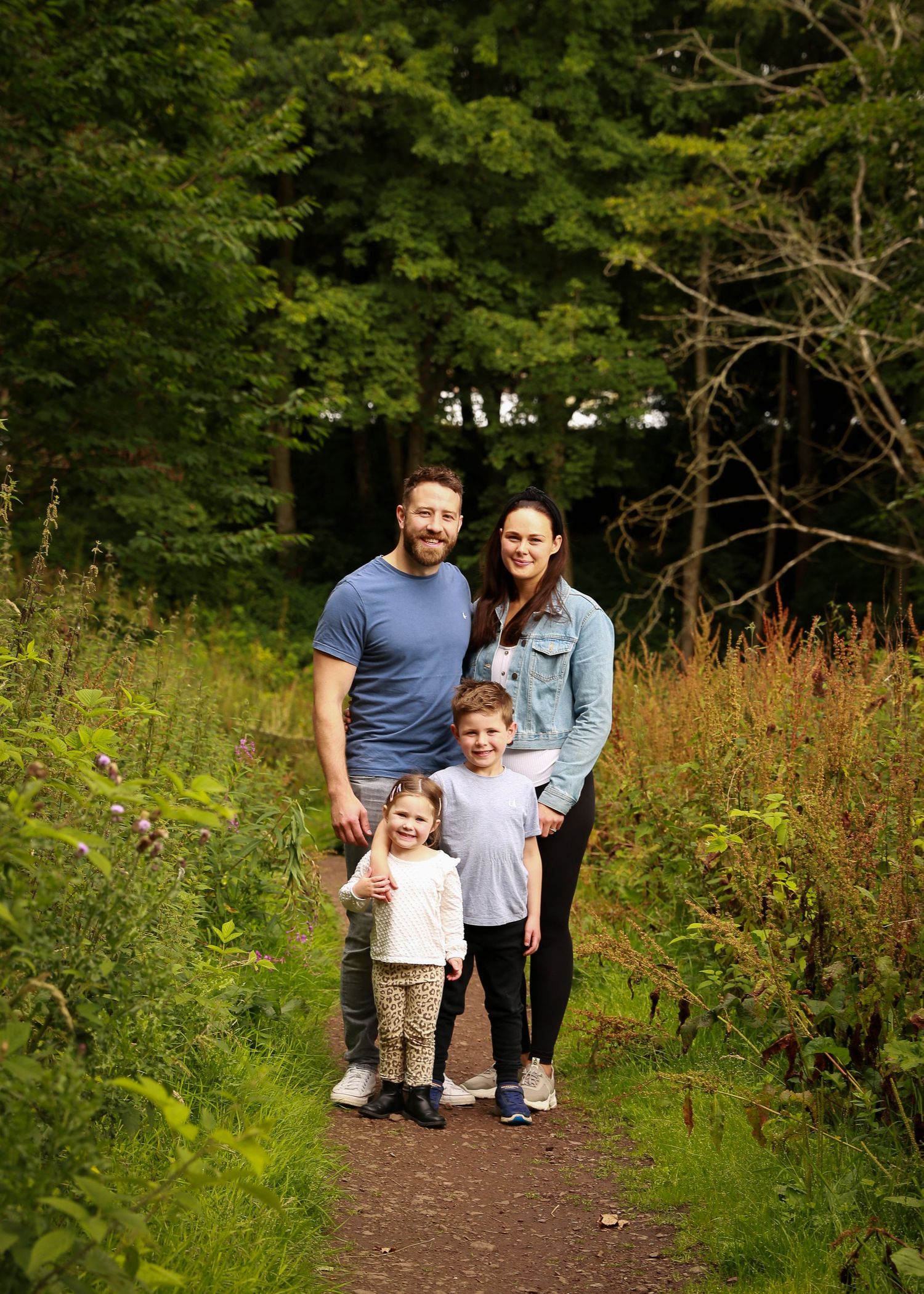 A joyful family enjoying a moment together in the tranquil surroundings of Dunnottar Woods, capturing the beauty of nature and connection