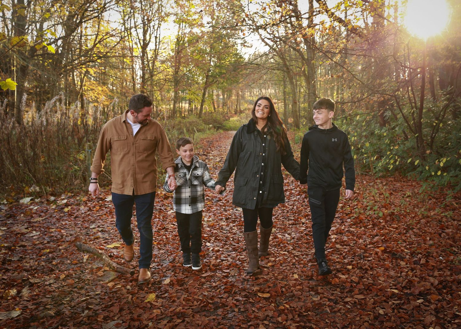 A joyful family enjoying a moment together in the tranquil surroundings of Dunnottar Woods, capturing the beauty of nature and connection