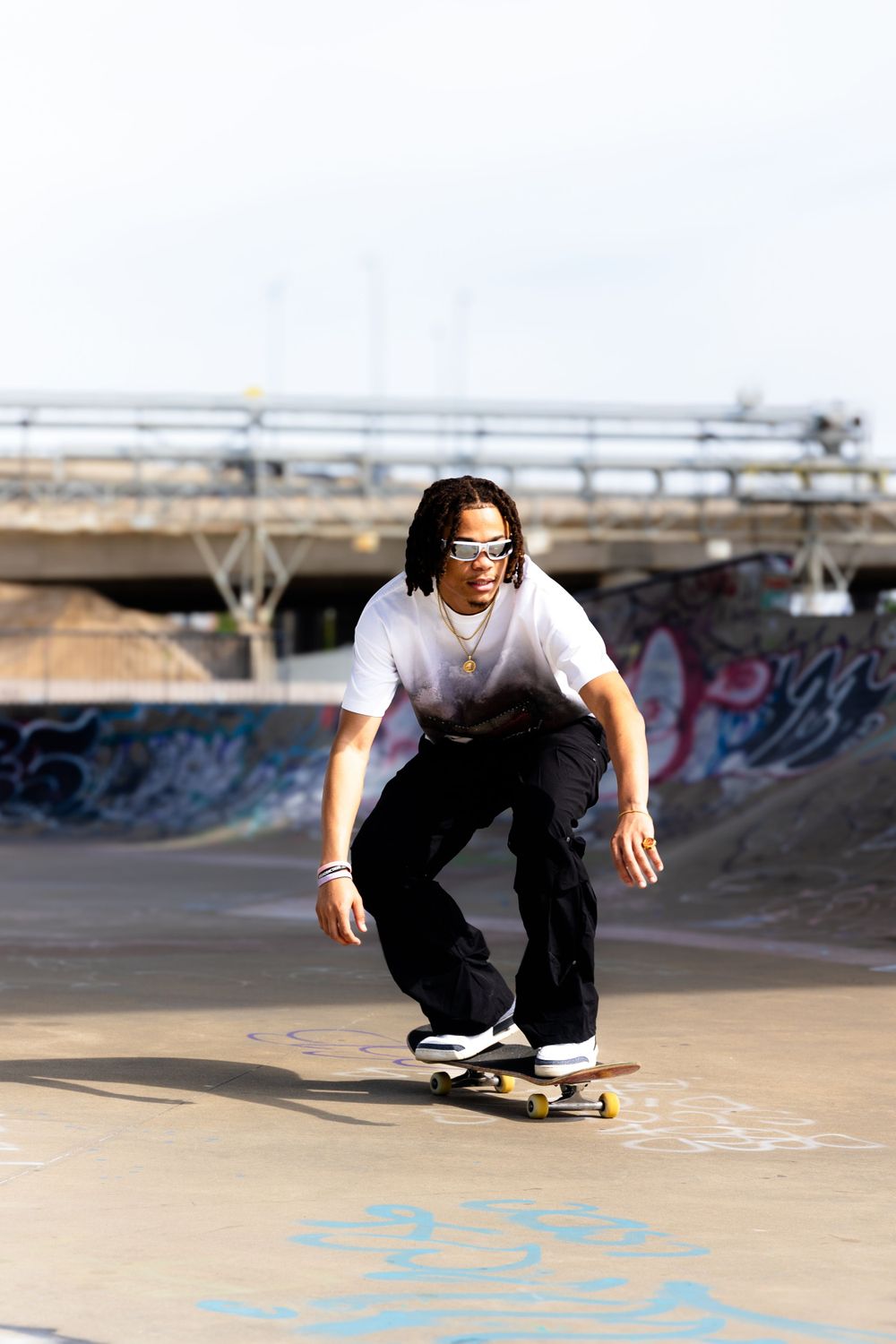 Skateboarder performing a trick on a concrete ramp at an outdoor skate park.