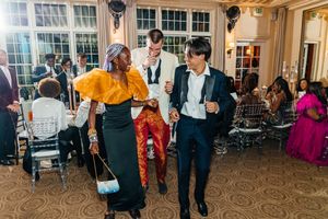 Guests dancing and socializing at an elegant indoor wedding reception with colorful attire.