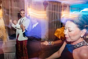 Guests dancing and celebrating at an elegant wedding reception with warm ambient lighting.
