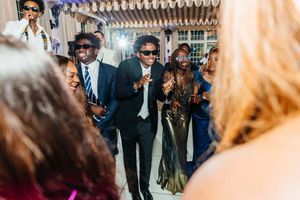 Guests dancing and celebrating at an elegant indoor wedding reception party.