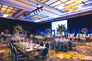 Elegant gala banquet hall with floral centerpieces, blue lighting, and formal table settings at The Fox event venue.