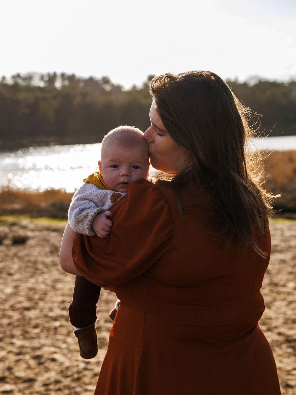 Moeder kust liefdevol voorhoofd van baby - new born lifestyle fotografie in de natuur - Sonse vennen - MaxFotos