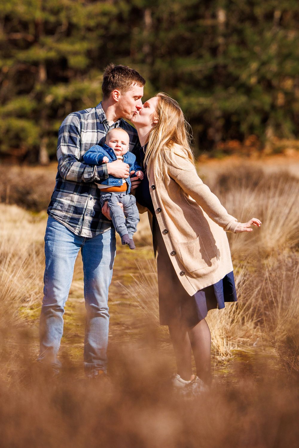 Ouders kussen elkaar - new born lifestyle fotografie in de natuur - natuurlijk licht - Sonse vennen - MaxFotos