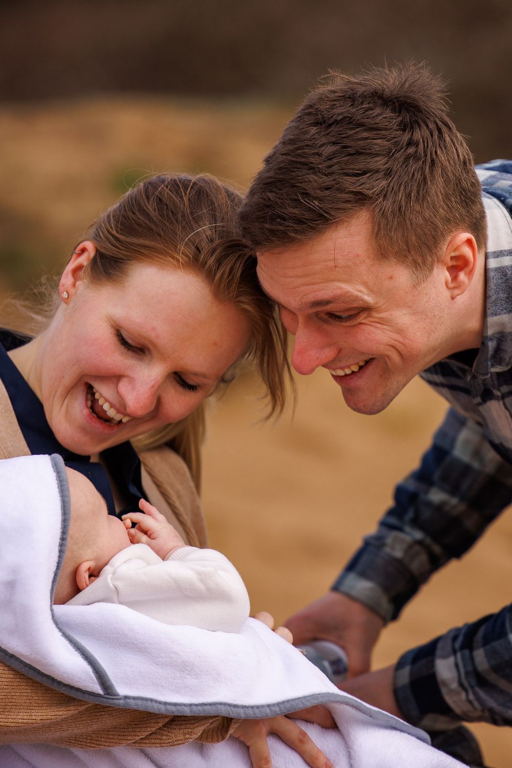 Ouders lachen naar baby - new born lifestyle fotografie in de natuur - natuurlijk licht - Sonse vennen - MaxFotos