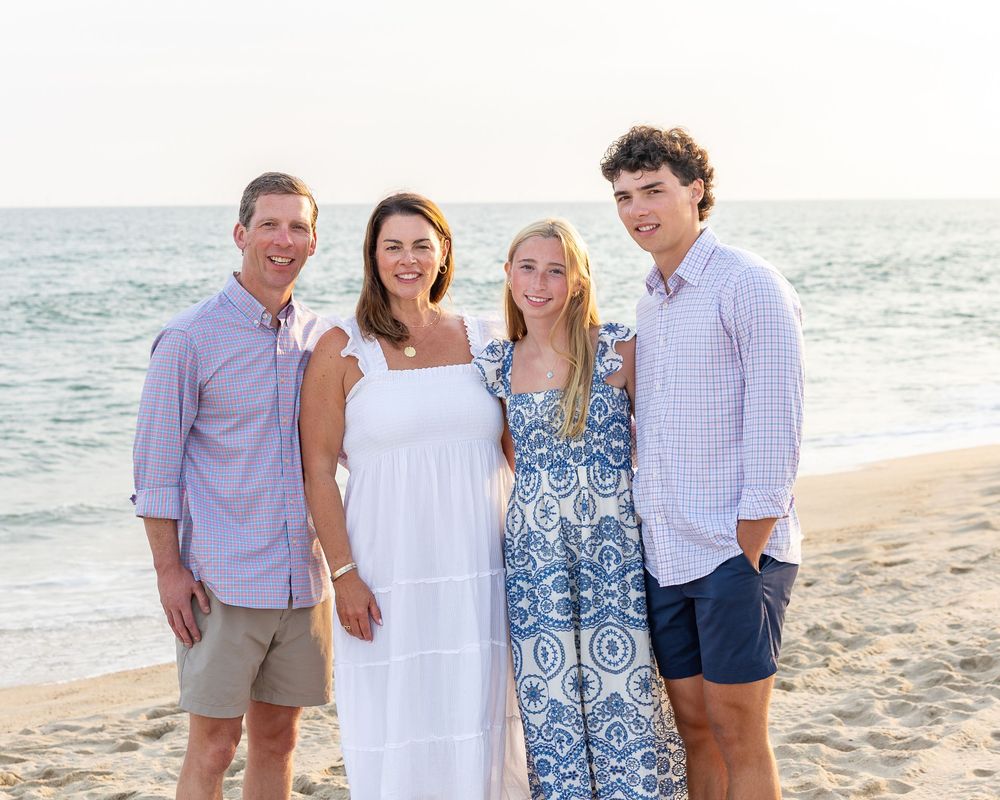 Family poses together on a Miacomet beach on Nantucket, MA. Beach family photos available on Cape Cod- Eastham, Orleans, Chatham, Nantucket.