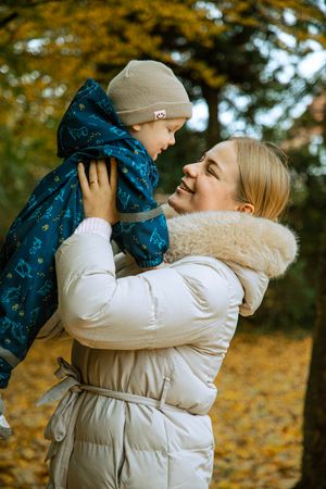 Natürliche Familienfotografie mit einer jungen Frau und einem Kind im Freien.