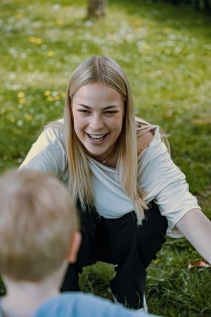 Natürliche Familienfotografie mit einer jungen Frau und einem Kind im Freien.