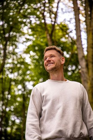 Ein Mann im Wald schaut in den Himmel