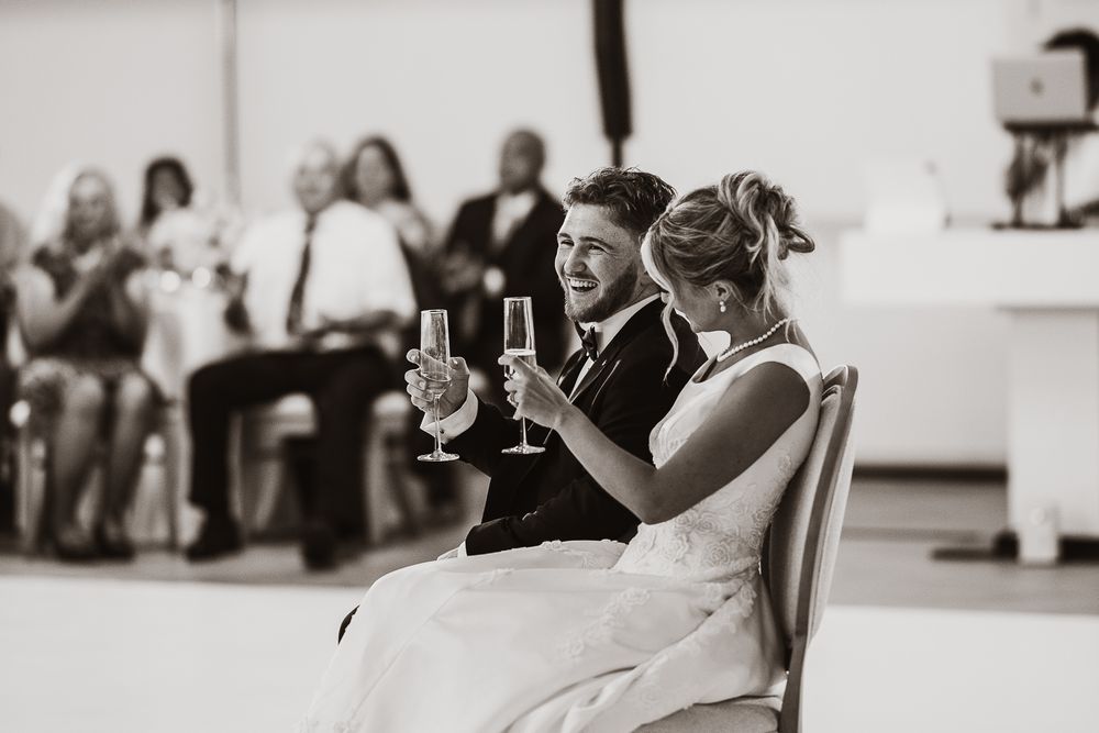 Documentary editorial wedding photography in Iowa by My Muse Weddings shows a couple toasting in The Clubhouse at Talons, Iowa.