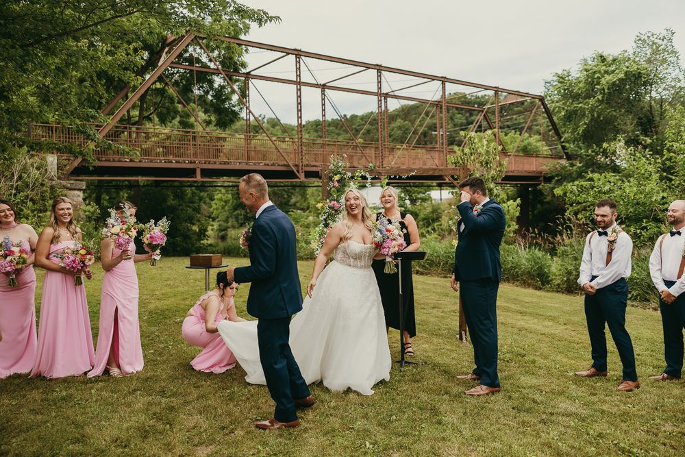 Documentary editorial wedding photography in Iowa by My Muse Weddings shows a father's laughter when handing over his daughter to groom.