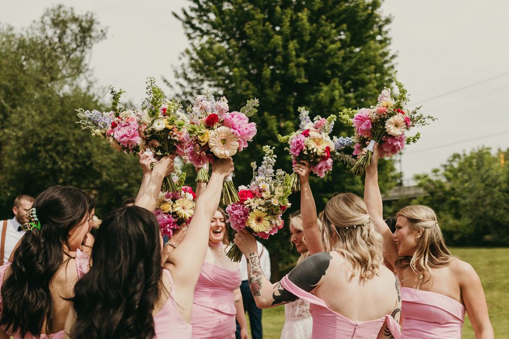 Documentary editorial wedding photography in Iowa by My Muse Weddings shows bridesmaids cheering the bride on shortly after saying "I DO!"