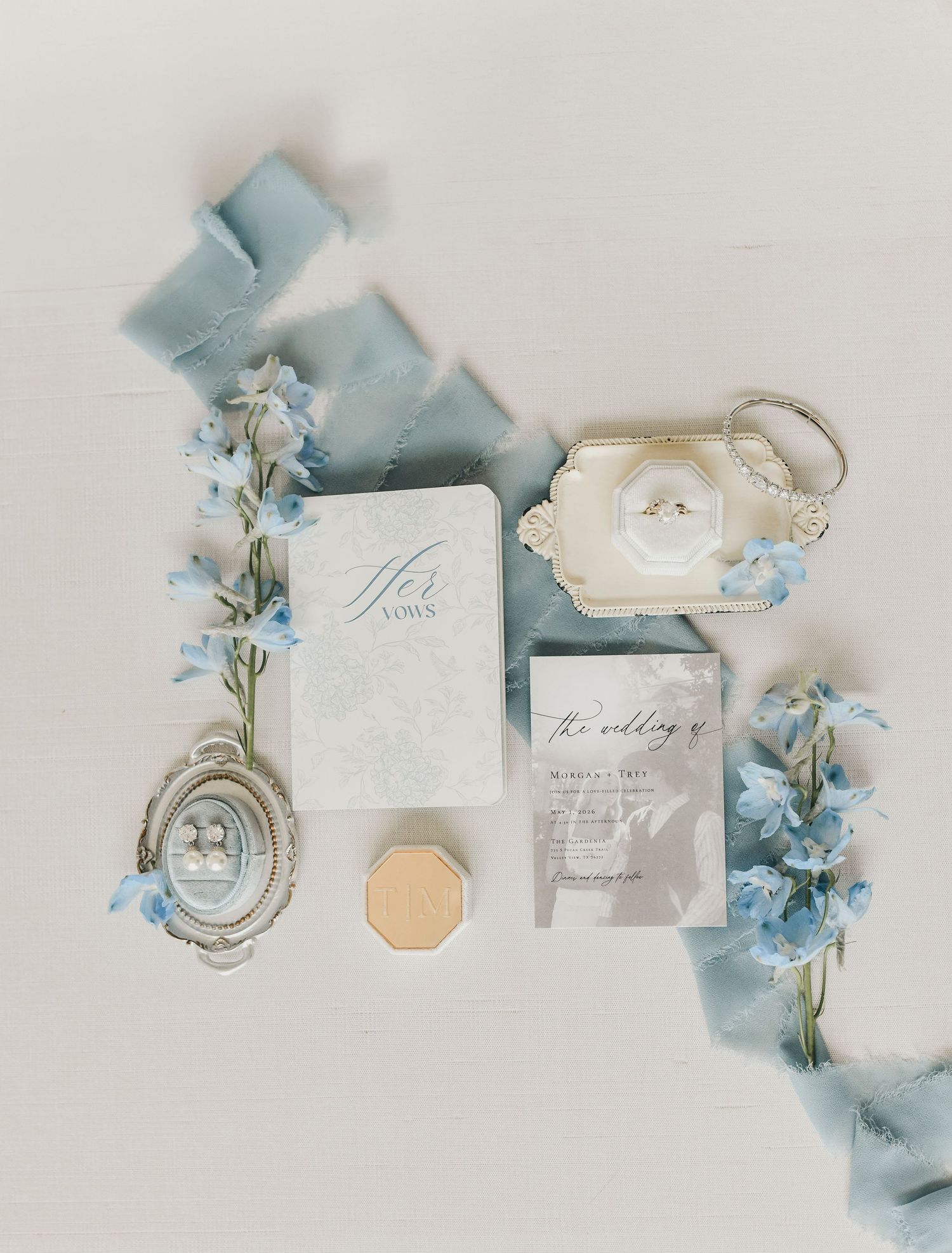 Dust blue ribbon and floral wedding flat lay