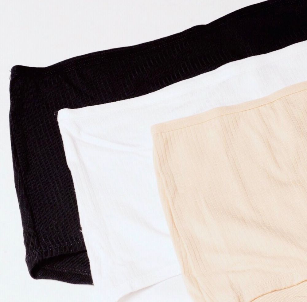 Three pack of ribbed high-waist briefs in black, white, and nude beige colors.