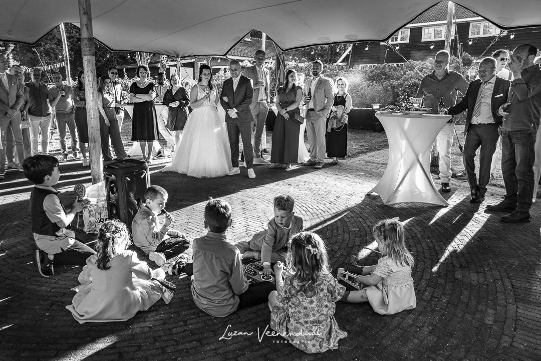 Kinderen zingen en spelen muziekinstrumenten voor Jesse en Sharon tijdens de barbecue onder de tent bij Zoomers aan het Bos in Castricum, va