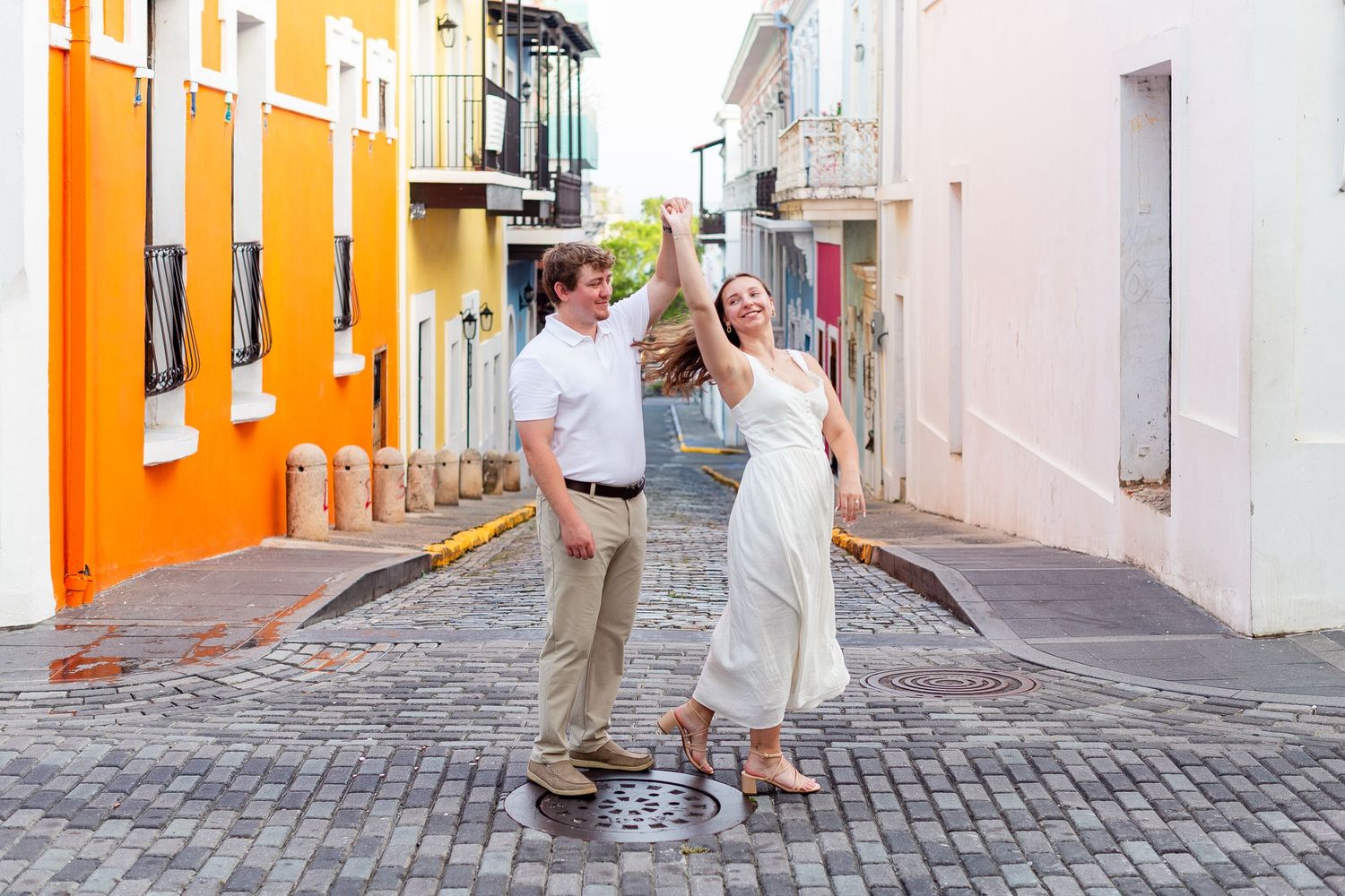 Man twirling woman. Engagement photo session in Old San Juan, Puerto Rico.