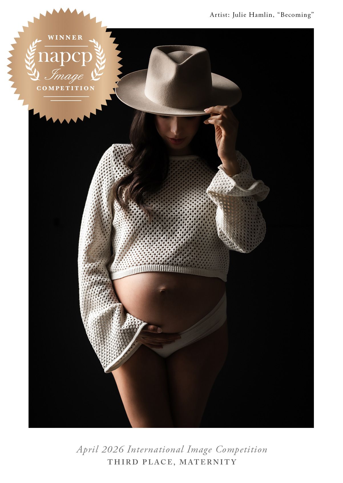 Award-winning maternity photo of pregnant woman in white mesh crop top and wide-brim hat on dark background.