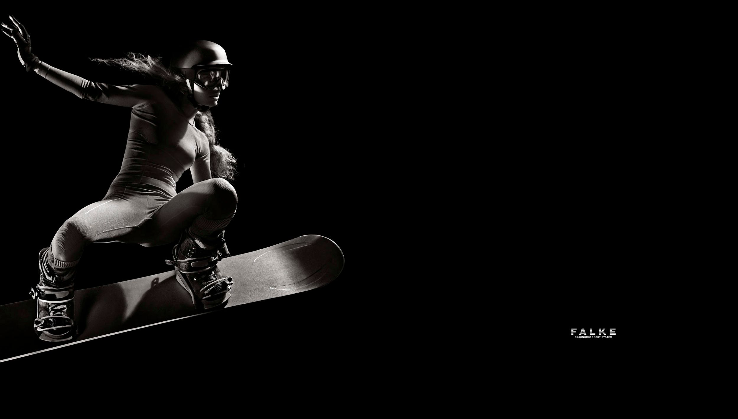 Dynamic black and white photo of skateboarder performing aerial trick against dark background.