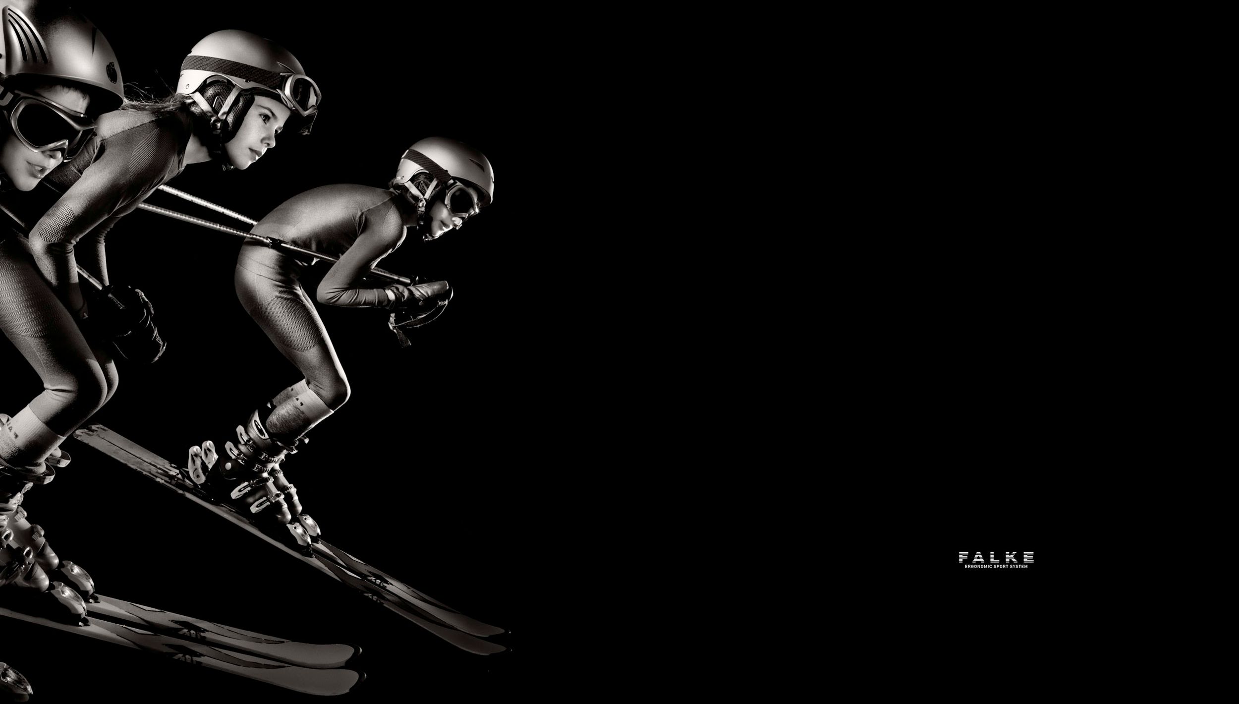Three skiers in aerodynamic suits race downhill in a dramatic black and white photo with FALKE branding.